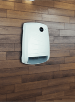 A modern white wall-mounted electric heater displays a digital temperature of 23 degrees against a dark wood-paneled wall.