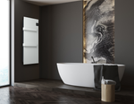 A sleek white freestanding bathtub and a modern wall-mounted electric radiator enhance a minimalist luxury bathroom featuring dark walls and wood herringbone flooring.