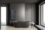 A sleek matte black freestanding bathtub rests on herringbone wood flooring in a minimalist modern bathroom with dark gray walls and large windows.
