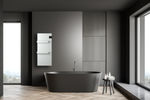 A sleek black freestanding bathtub sits in a modern minimalist bathroom featuring dark gray walls and a white wall-mounted electric towel warmer.